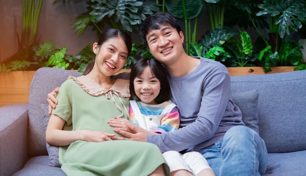 Młoda azjatycka rodzina z matką w ciąży w domu