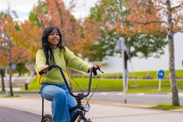 Młoda azjatycka studentka z plecakiem na rowerze w drodze na studia jesienią zdrowe życie przyjazne dla środowiska