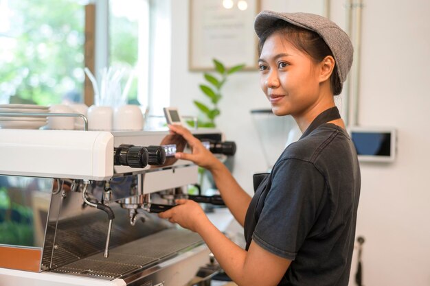 Młoda baristka nastawiona na obsługę, pracująca w kawiarni!