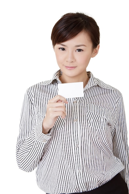 Młoda biznesowa kobieta trzyma pustą kartę na białej ścianie.