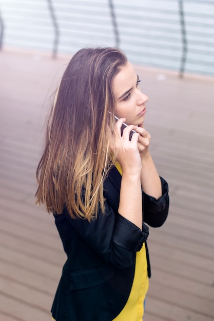 Zdjęcie młoda biznesowa kobieta używa telefon komórkowego przy ulicą