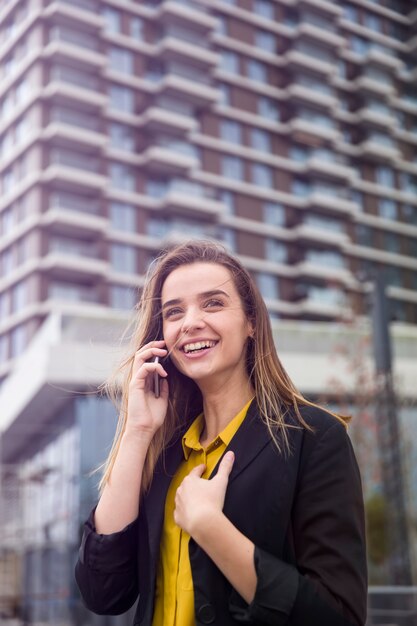 Młoda biznesowa kobieta używa telefon komórkowego przy ulicą