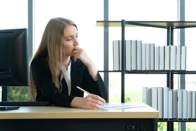 Zdjęcie młoda bizneswoman cierpiąca na stres pracując przy biurowym komputerze na biurku