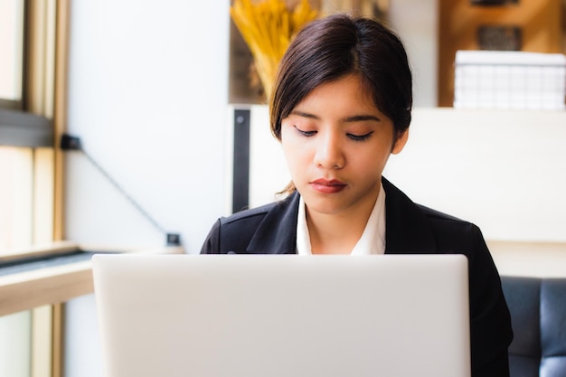 Młoda bizneswoman pracująca na laptopie w biurze