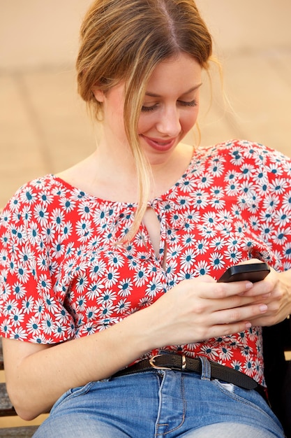 Młoda blond kobieta patrzeje telefon komórkowego