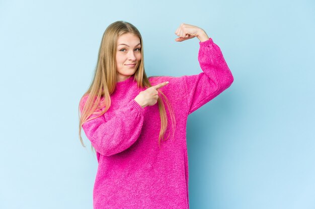 Zdjęcie młoda blond kobieta pokazuje gest siły z rękami