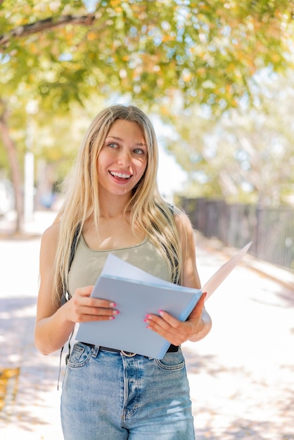 Zdjęcie młoda blond studentka na zewnątrz