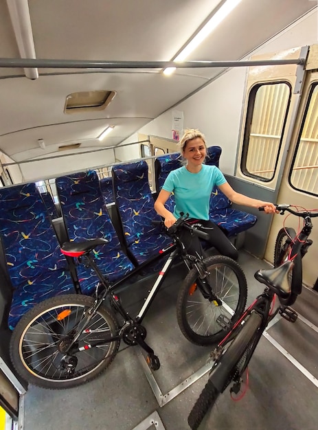 Młoda blondynka jeździ z dwoma rowerami w transporcie miejskim Turystyka sport i aktywna rekreacja