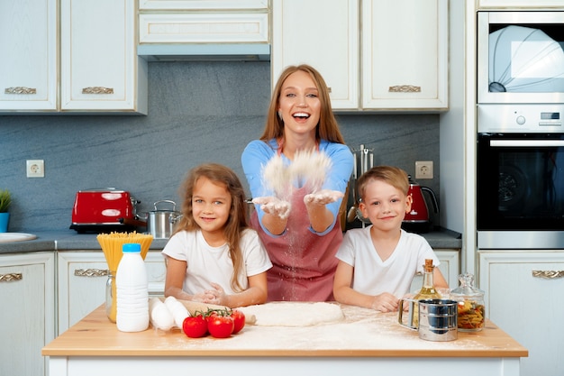 Młoda Blondynka, Matka I Jej Dzieci Bawią Się Podczas Gotowania Ciasta