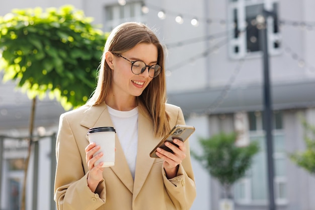 Młoda blondynka na tle centrum biznesowego centrum biznesowego Portret udanego startupu Smartphone kawa casual suit