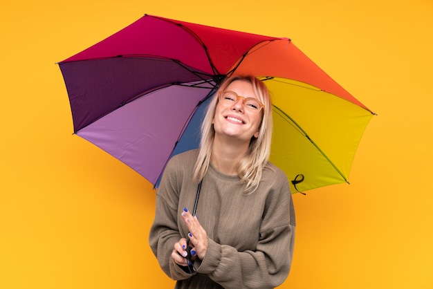 Młoda Blondynki Kobieta Trzyma Parasol Nad Odosobnionym Kolor żółty ściany Oklaskiwać
