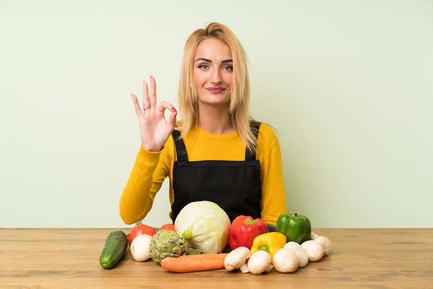 Młoda Blondynki Kobieta Z Udziałami Warzywa Pokazuje Ok Znaka Z Palcami