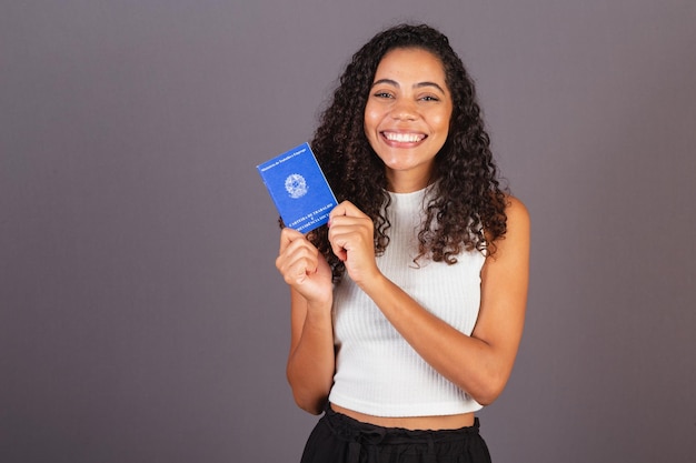 Młoda brazylijska czarna kobieta trzyma portfel roboczy CLT Work and Social Security Card