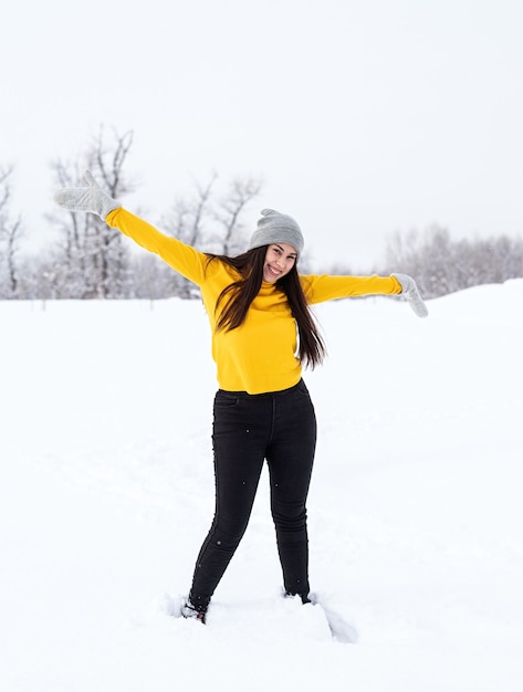 Młoda brunetka kobieta bawić się śniegiem w parku
