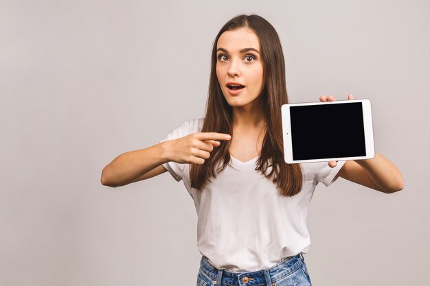 Młoda brunetka kobieta trzymając tabletkę