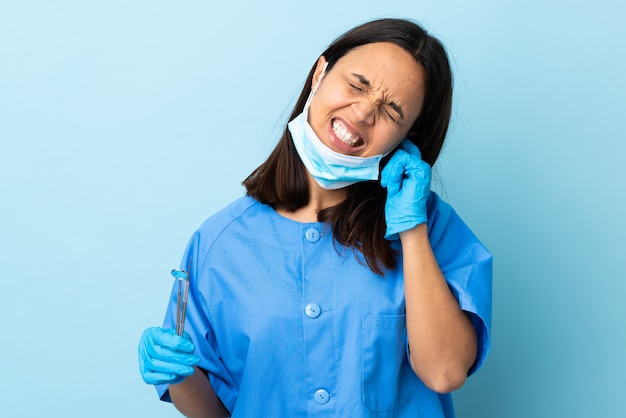 Młoda Brunetka Mieszająca Biegowa Dentysta Kobiety Mienia Narzędzia Nad Odosobnionym Tłem Udaremniającym I Zakrywającymi Ucho