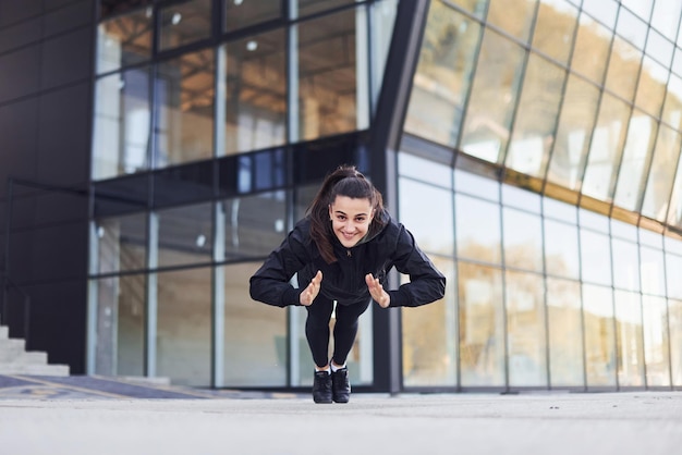 Młoda brunetka w sportowym stroju ma dzień fitness na świeżym powietrzu w mieście