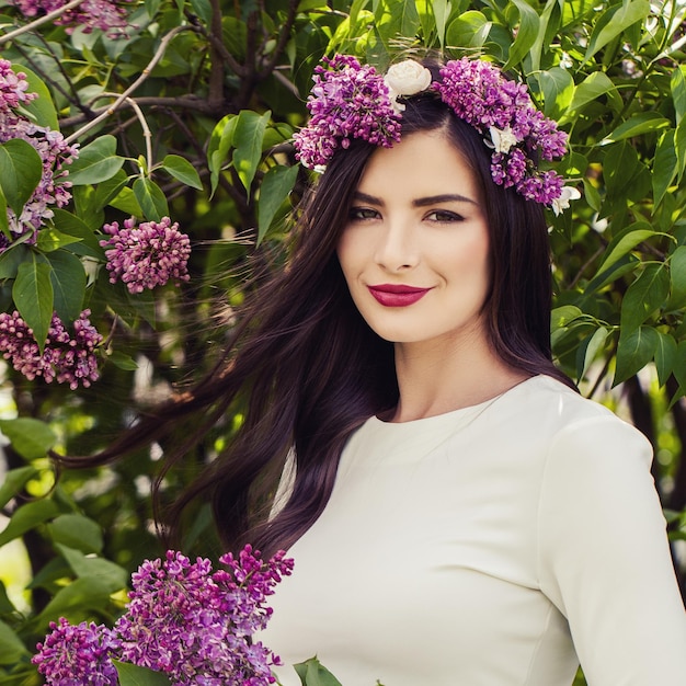 Młoda brunetka z makijażem i kwiatami na zewnątrz letni portret