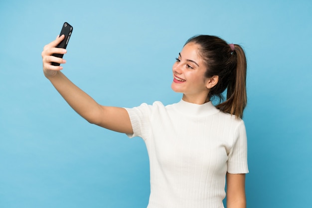 Młoda brunetki dziewczyna nad odosobnionym brać selfie z wiszącą ozdobą