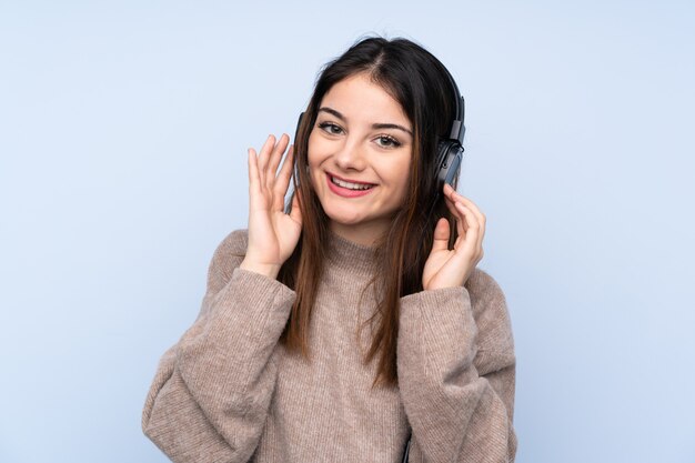 Młoda Brunetki Kobieta Nad Błękit ściany ścianą Słuchającą Muzykę