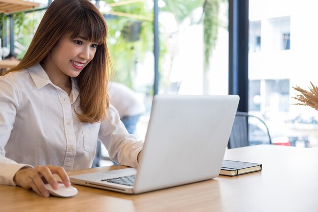 młoda businesswoman pracy z przenośnego laptopa i dokumentów w biurze