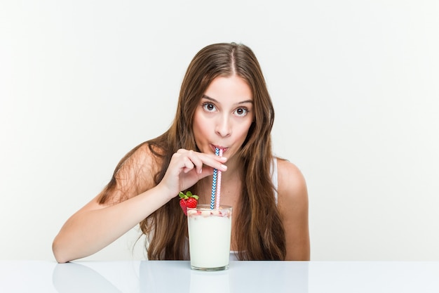 Młoda caucasian kobieta pije smoothie