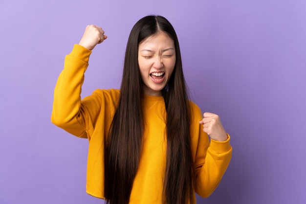 Młoda Chińska dziewczyna nad odosobnionym purpurami świętuje zwycięstwo