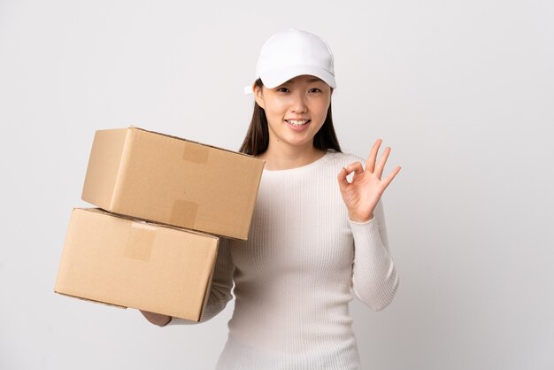 Młoda chińska kobieta dostawy na pojedyncze białym tle przedstawiający znak ok palcami