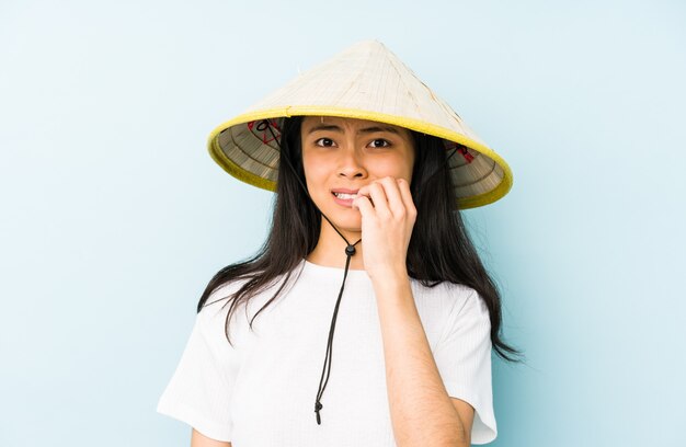 Młoda chińska kobieta jest ubranym wietnamczyka siano krzyczy i trzyma palmowego pobliskiego rozpieczętowanego usta.