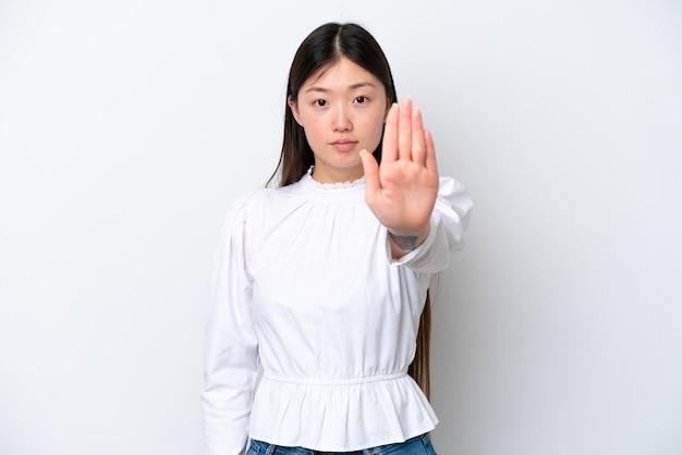 Młoda chińska kobieta odizolowywająca na białym tle robi gestowi stop