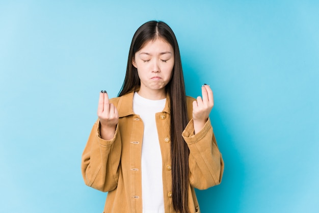 Młoda chińska kobieta pozuje w błękitnej ścianie pokazuje, że ona żadny pieniądze.