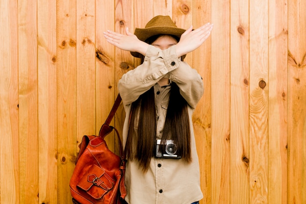 Zdjęcie młoda chińska podróżnik kobieta utrzymuje dwa ręki krzyżował, zaprzeczenia pojęcie.