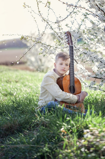 Młoda chłopiec bawić się na gitarze plenerowej