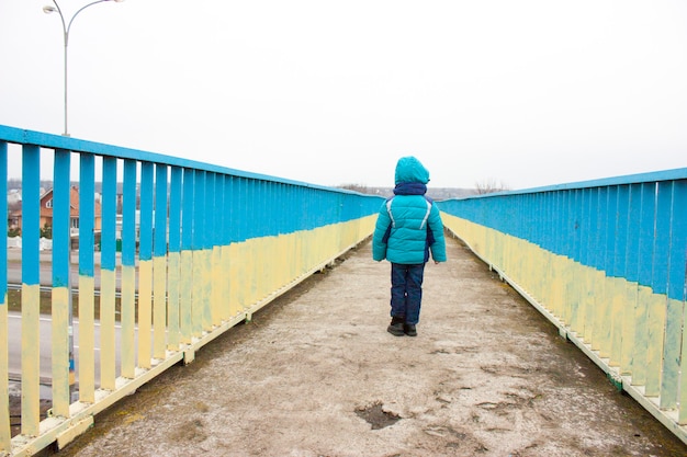 Młoda chłopiec biegnie przez most