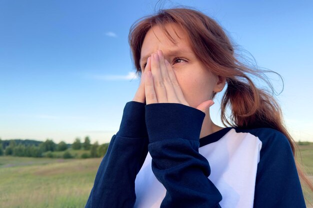 Zdjęcie młoda chora kobieta z alergią na pyłki na świeżym powietrzu w letni dzień kicha
