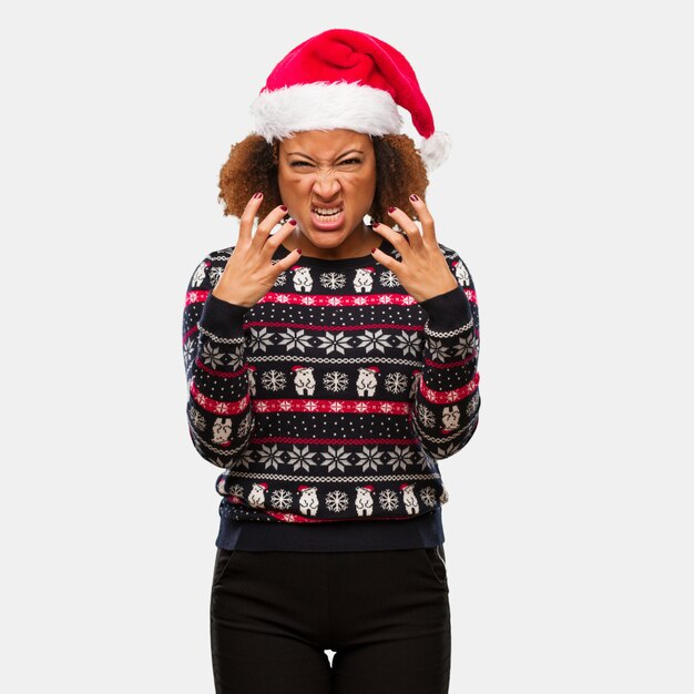 Młoda czarna kobieta w modny sweter christmas z nadrukiem zły i zdenerwowany