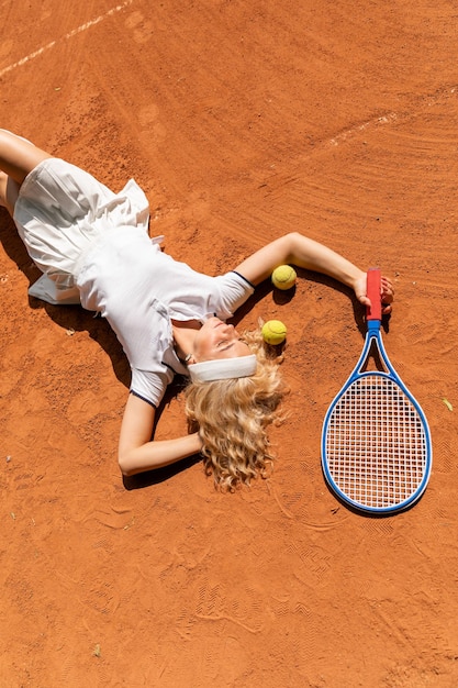 młoda dama leży na trawniku w białym stroju sportowym