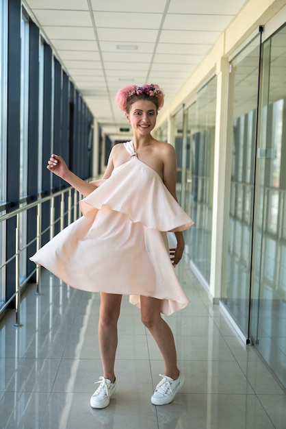 Zdjęcie młoda dama w długim korytarzu pozuje w różowej sukience glamour