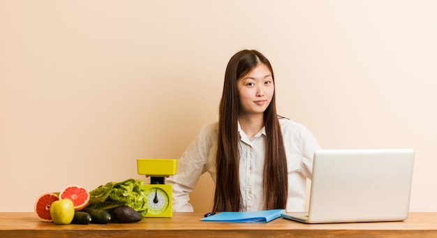 Młoda dietetyka chińska kobieta pracuje z jej laptopem zbeształ kogoś bardzo gniewnego.