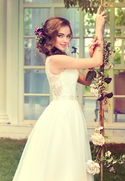 Młoda, doskonale wyglądająca panna młoda ubrana w piękną i szykowną suknię ślubną.