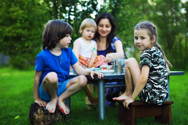 Młoda duża rodzina na pikniku w letni poranek Piękna mama z dziećmi je śniadanie w parku