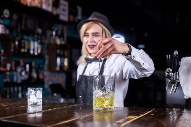 Młoda dziewczyna barmana robi show, tworząc koktajl w koktajl barach