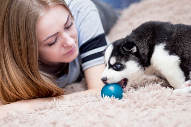 Młoda Dziewczyna Bawi Się Ze Szczeniakiem Husky Syberyjskiego