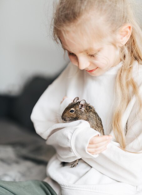 Młoda dziewczyna bawiąca się z małą wiewiórką degu