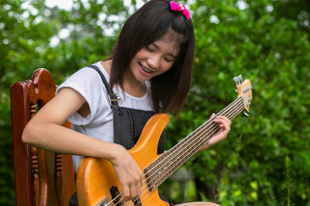 Zdjęcie młoda dziewczyna bawić się na basowej gitarze