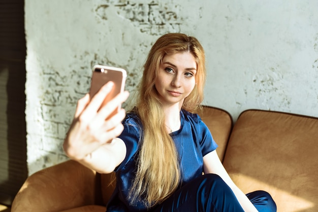 Zdjęcie młoda dziewczyna bierze selfie w domu