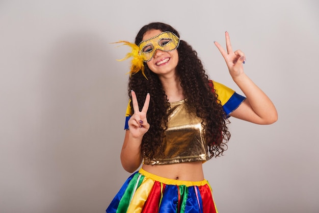 Młoda dziewczyna brazylijska z frevo odzież karnawałowa maska znak pokoju i miłości pozuje do zdjęcia zbliżenie