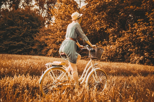 Młoda dziewczyna czyta książkę na tle retro roweru.