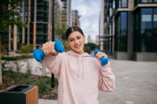 Młoda Dziewczyna Fitness Robi ćwiczenia Z Hantlami W Parku Miejskim