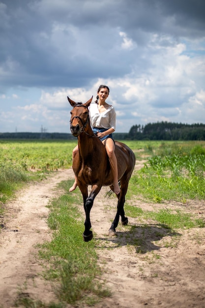 Młoda dziewczyna jedzie na brązowym koniu z bliska